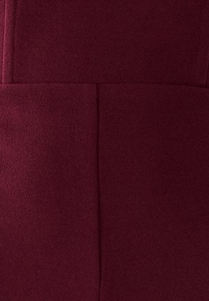Tejido burdeos, superficie texturizada con un acabado suave. Presenta líneas y costuras limpias, mostrando un diseño simple sin embellishments visibles.