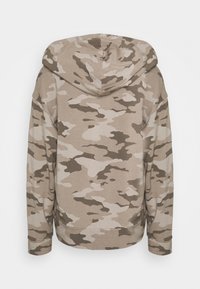 Huvtröja med ett beige och brunt kamouflage-mönster, tillverkad av mjukt tyg med en avslappnad passform och ribbade muddar och fåll.