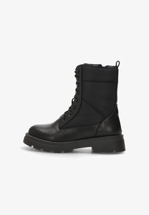 Botas de combate negras con un acabado de cuero suave, parte superior acolchada y suela de goma. Cuenta con un diseño de cordones y una tira en la parte trasera para facilitar su uso.