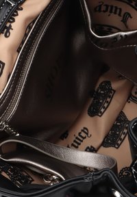 Zwarte handtas met een gladde textuur, voorzien van een metallic gouden binnenkant bedrukt met kronen en "Juicy" in vetgedrukte letters, en een ritszak.