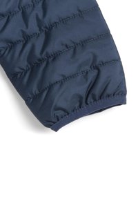 Manche de veste matelassée isolante bleu marine avec un design en piqûres, un poignet élastique et une texture lisse, offrant chaleur et confort.