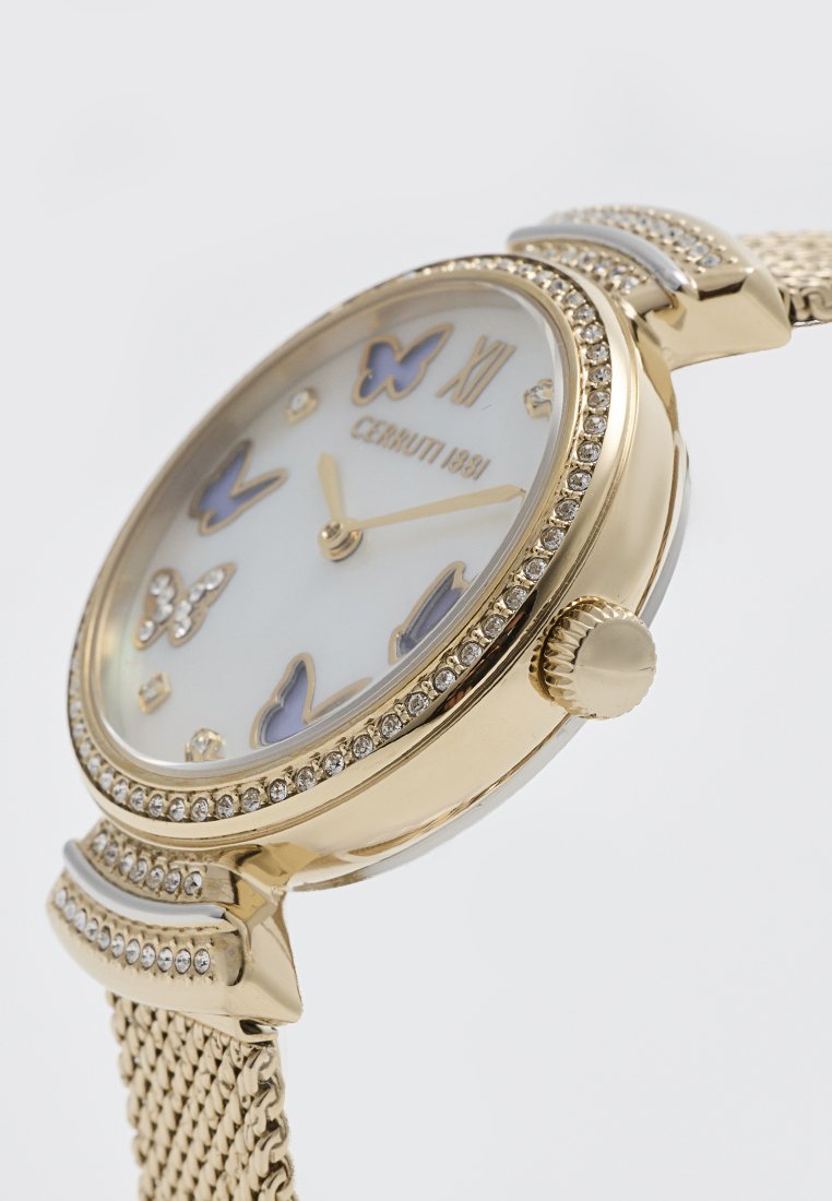Montre-bracelet en ton or avec un cadran rond blanc présentant des motifs de papillons et des accents en cristal. Bracelet en maille pour une finition texturée.