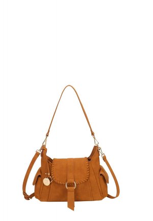 Sac d'épaule en daim marron avec fermeture à rabat, bordure tressée, poches latérales, bretelles réglables et un pendentif rond en métal doré suspendu sur le côté.