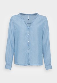 Chemise en denim bleu clair à manches longues, col en V, boutonnée devant, avec un détail froncé aux épaules. Texture douce avec une coupe décontractée.