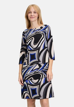 Farbenfrohes Kleid mit einem auffälligen abstrakten Muster in Blau, Schwarz und Grau. Hergestellt aus glattem Stoff mit einer figurbetonten Silhouette und Dreiviertelärmeln.