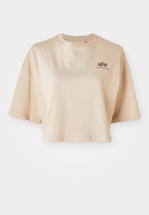 Beige avskåret t-skjorte laget av bomull, med korte ermer, rund hals, og en burgunder logo grafikk på venstre bryst.