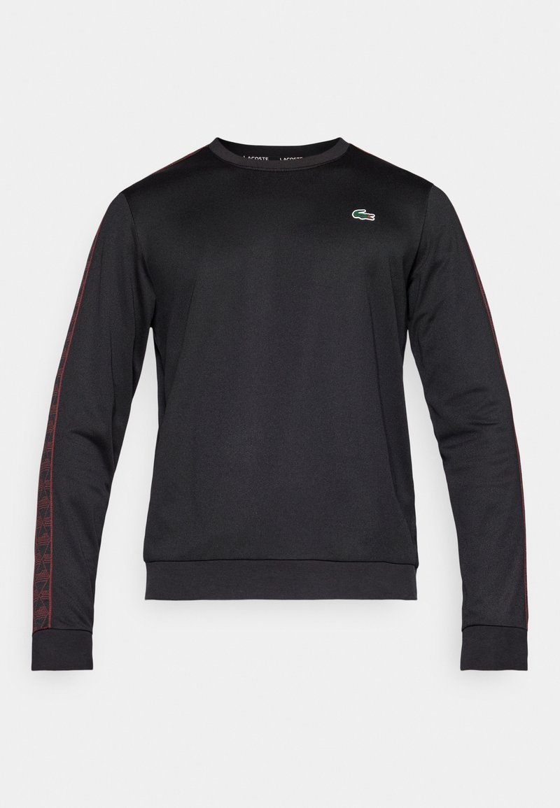 Sweat-shirt noir à manches longues avec des rayures latérales à motifs rouges et un logo brodé vert sur la poitrine. Fabriqué en tissu léger.