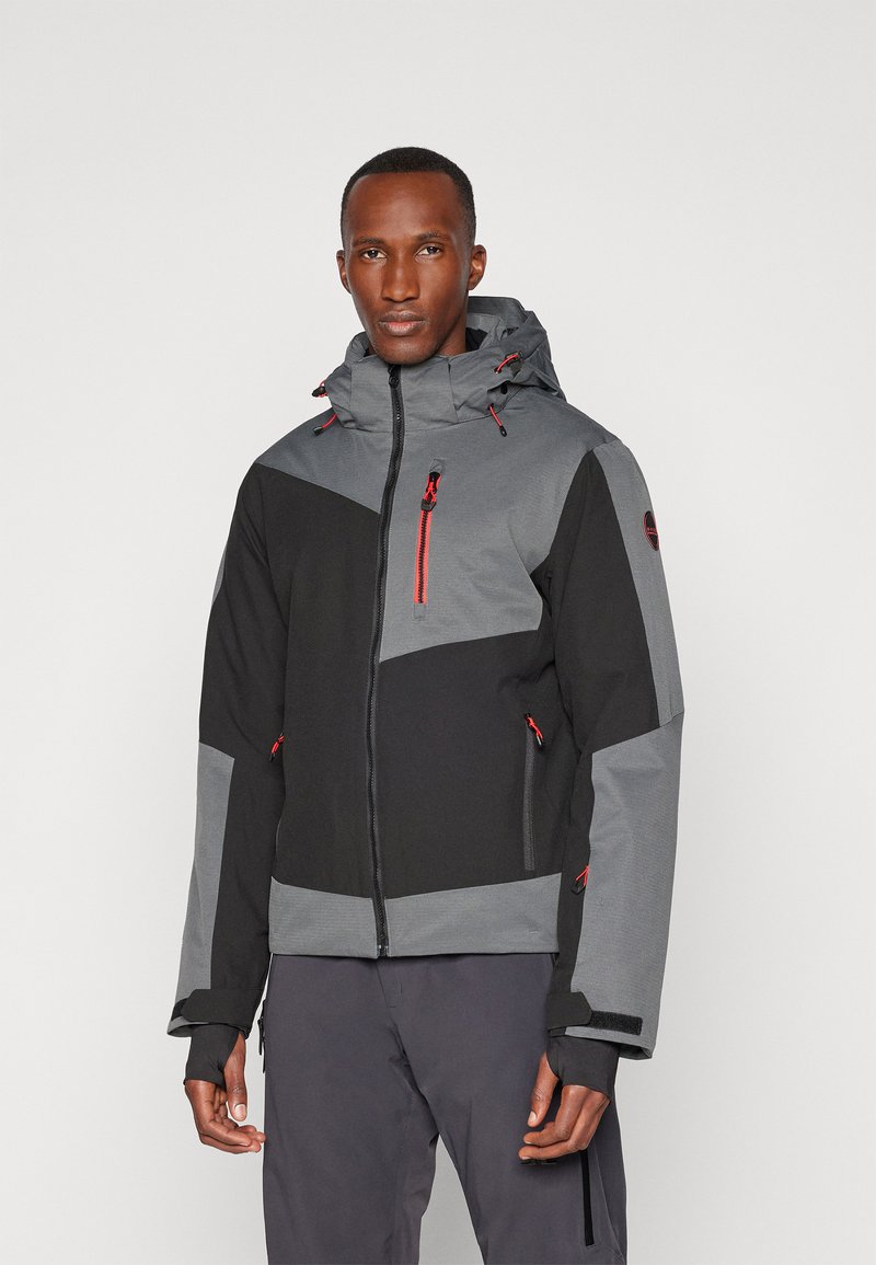 Chaqueta en bloques de color en negro y gris, con cremallera frontal, capucha ajustable y cremalleras de acento rojas. Confeccionada con material texturizado.