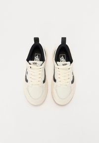 White lace-up sneakers with black accents and a textured fabric upper. Features a padded collar and a small logo on the tongue.