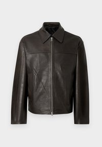 Brūna ādas jaka ar rāvējslēdzēja aizdari, šaura apkakle, taisns piegriezums un divas sānu kabatas. Teksturēta virsma ar smalku spīdumu.