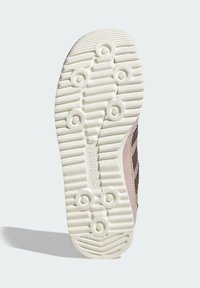 Potplat cipele od bijele gume s teksturiranim uzorcima za prijanjanje i okruglim naglascima; s utisnutim detaljima brenda na bočnoj strani.