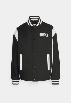 Czarna kurtka varsity z białymi rękawami i prążkowanym kołnierzem. Posiada zapięcie na guziki, kieszenie boczne oraz logo "TOMMY Jeans" z przodu.