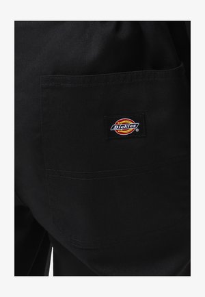 Pantaloni da lavoro neri realizzati in tessuto resistente, con una tasca applicata e un logo "Dickies" colorato sul retro.