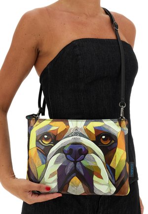 Borsetta a mano con motivo geometrico colorato che rappresenta il volto di un cane, realizzata in tessuto strutturato. Dotata di tracolla nera rimovibile e chiusura con cerniera.