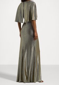 Dlouhé, přiléhavé šaty vyrobené z metalického zlatého materiálu s vysokým zadním dílem a volnými rukávy. Hladká textura s mírným leskem.