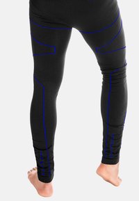 Schwarze Sportleggings mit blauen Nahtmustern, einer glatten Textur und einem figurbetonten Design, das direkt über dem Knöchel endet, mit sichtbaren baren Füßen.