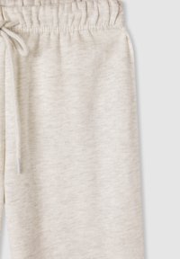 Jasnoszare spodnie dresowe wykonane z miękkiego, strukturalnego materiału, z elastycznym pasem i sznurkiem do regulacji dopasowania.