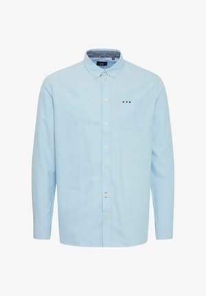 Lys blå langermet skjorte laget av bomull, med krage som kan kneppes ned, én brystlomme og subtile fargeaksenter på lommen.