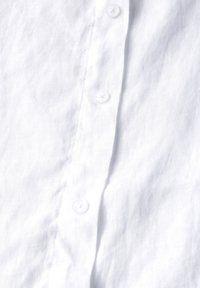 Weißes Leinenhemd mit glatter Textur und sichtbarem Webmuster. Verfügt über fünf kleine, runde, transparente Knöpfe entlang der Vorderseite.
