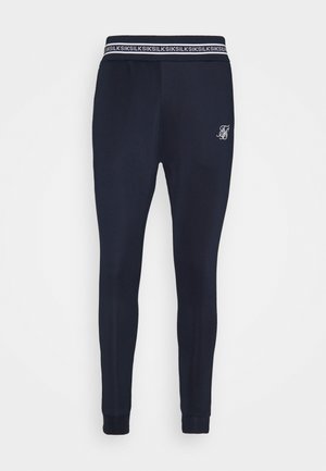 Pantalones deportivos slim fit navy con cintura elástica que presenta texto repetido "SIKSILK" y pequeño logo bordado blanco en el muslo izquierdo.