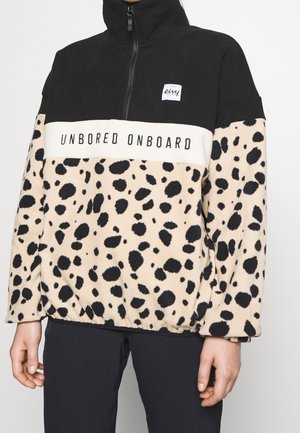 Persoon draagt een zwarte en beige fleece met luipaardprint en halve rits, met de tekst "UNBORED ONBOARD" op de borst en een klein "eivy"-logo erboven.
