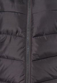 Sort puffer vest med lang lynlås, vandret quilted syninger og en slank, blank finish. Letvægts og isoleret design.