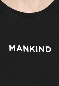 Černé bavlněné tričko s kulatým výstřihem a nápisem "MANKIND" v tučném bílém písmu přes hrudník. Hladká textura.