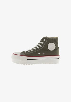 Baskets hautes en toile verte avec des lacets blancs, embout en caoutchouc et semelle blanche épaisse avec une accent rouge et un patch logo.