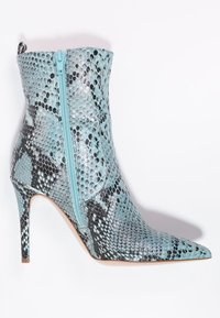 Spetsig tå ankelsk boot i ljusblå konstläder med ormskinnsstruktur och en kontrasterande dragkedjedetalj på sidan. Hög stilettklack.