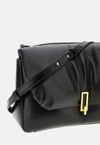 Borsa a tracolla nera in pelle con una forma strutturata, un soffice pattino superiore, dettagli in metallo dorato e una tracolla regolabile. Finitura testurizzata sul materiale.
