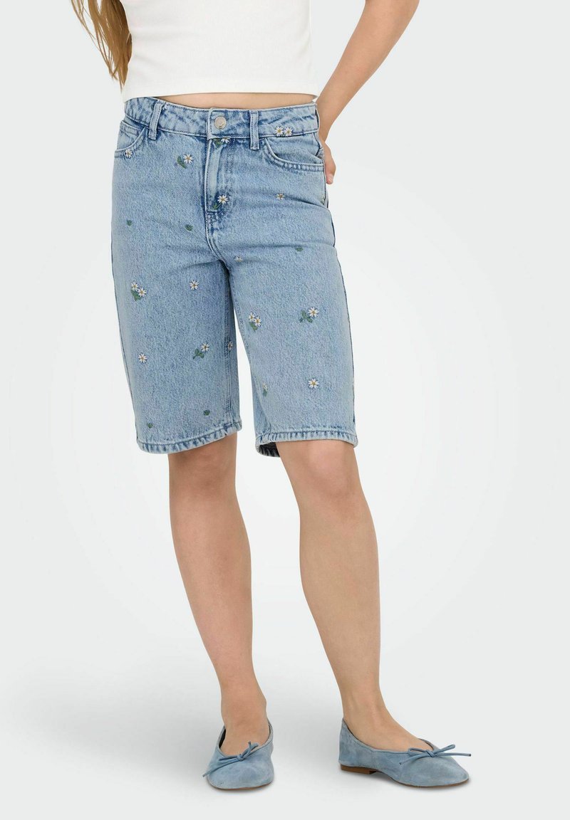 Denim šortos ar ziedu izšuvumu baltā un zaļā krāsā, ar augstu jostasvietu, jostu cilpiņām un sarullētu apakšmalu. Gaismas zilā krāsā.