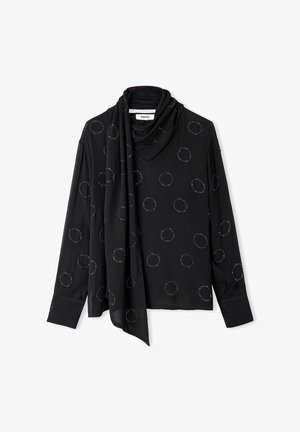 Haut à manches longues noir en tissu doux, avec un col drapé et des embellissements circulaires dispersés. Présente un accent de style écharpe.