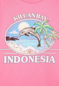 Delfin ugrik az óceáni hullámok felett pálmafákkal, tengeri csillagokkal és a „KILUAN BAY INDONESIA” szöveggel rózsaszín háttéren.