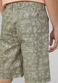Groene shorts met een wit tropisch patroon met ananassen en loof. Elastische tailleband en zichtbare zijzakdetails.