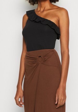 Zwarte top met één schouder en een gegolfde halslijn, gecombineerd met een bruine rok met een geknoopt ontwerp en ronde accentdetails.