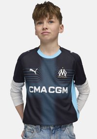 Sinine ja tumesinine jalgpallisaade, millel on tekstuuriline muster, Puma logo, meeskonna embleem ja valge "CMA CGM" tekst ees.