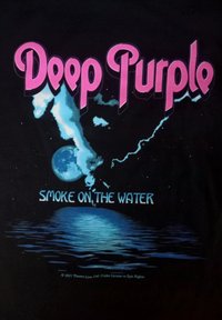 Černé tričko s nápisem "Deep Purple" v jasně růžovém písmu a "Smoke on the Water" v modré barvě níže. Design zahrnuje měsíc a odraz ve vodě.