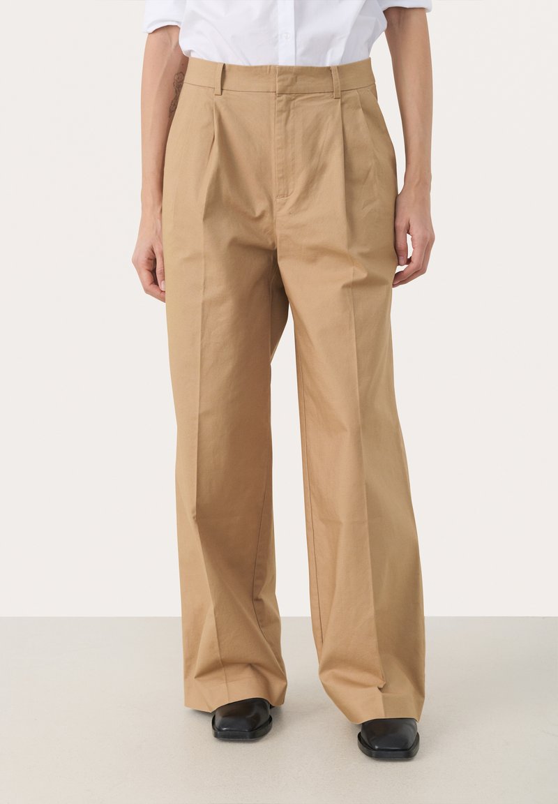Beige, hoch Taillenhose aus Baumwolle mit weitem Bein, ausgestattet mit vorderen Falten und einem glatten, matten Finish.