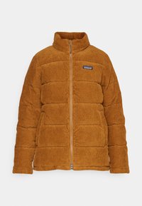 Giacca in corduroy imbottita di colore giallo senape con colletto alto, zip completa e patch con logo sul lato sinistro del petto, caratterizzata da una texture trapuntata.