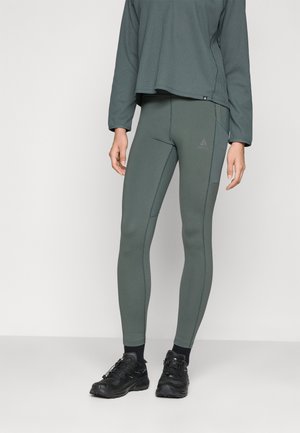 Green athletic leggings with a fitted design and contrasting seam lines, paired with a textured long-sleeve top in a darker shade of green.