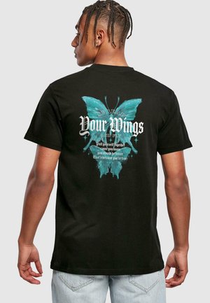 Black cotton t-shirt with a turquoise butterfly graphic and white text "Spread Your Wings and Fly" on the back. Short sleeves, relaxed fit.