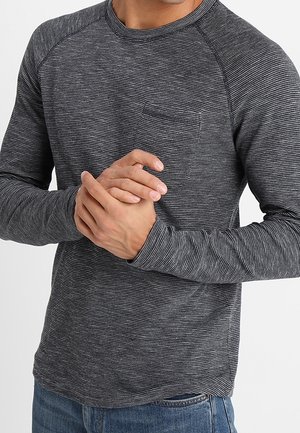 Camisa de manga larga en gris oscuro con rayas blancas, con un cuello redondeado y un pequeño bolsillo en el pecho. Tejido suave y texturizado.