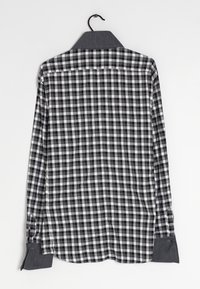 Camicia a maniche lunghe a quadri bianco e nero, in tessuto di cotone, con colletto tradizionale, polsini con bottoni e orlo arrotondato.
