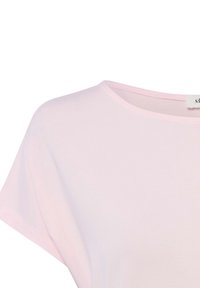 Hellrosa Kurzarmoberteil mit rundem Halsausschnitt, sichtbarer Schulternaht und einem Etikett im Kragen.