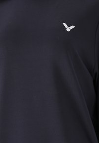 Mörkblå T-shirt i mjukt bomull med rund halsringning, prydd med en liten vit logotyp på övre vänstra sidan. Slät textur.