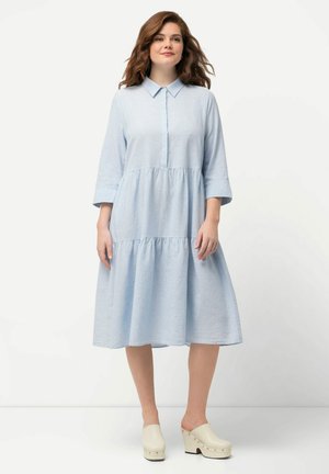 Himmelblaues, kragenloses Kleid mit Dreiviertelärmel, durchgehender Knopfleiste und einer gestuften, fließenden Rockpartie. Hergestellt aus einem leichten Stoff.