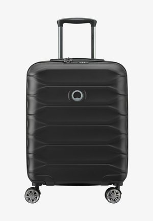 Black hard-shell suitcase with textured surface, featuring a retractable handle, four wheels, and a circular logo on the front.