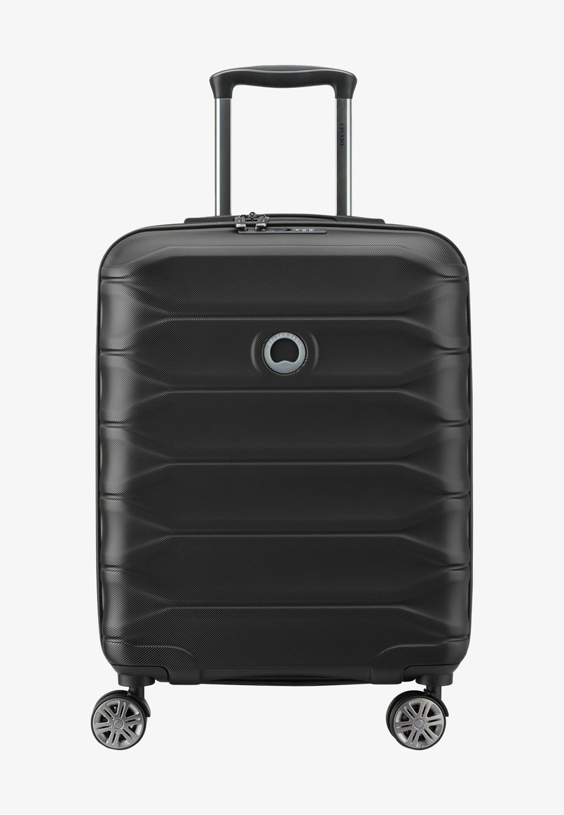 Maleta dura negra con superficie texturizada, que cuenta con un mango retráctil, cuatro ruedas y un logo circular en la parte frontal.