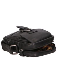 Borsa a tracolla in pelle nera con un compartimento con zip e una piccola patta frontale. Caratterizzata da un elemento decorativo in metallo e una tracolla regolabile.