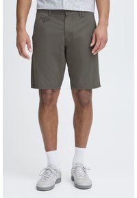 Olive green shorts made of lightweight fabric, featuring a button closure, front pockets, and a relaxed fit. Simple hemmed edges.